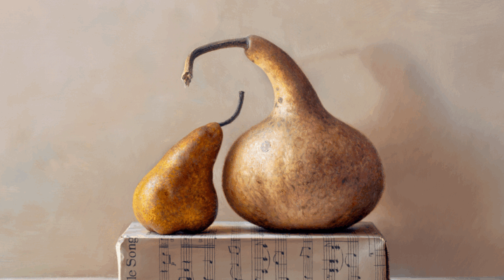 Two gourds, one small and one large, rest on a closed book with visible sheet music against a neutral background.